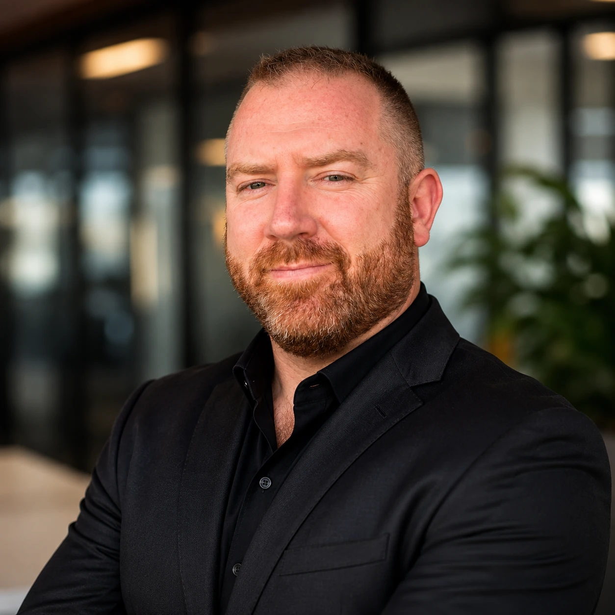 Portrait of Charles Sears. A personal branding headshot with warm light and a softly blurred office background.